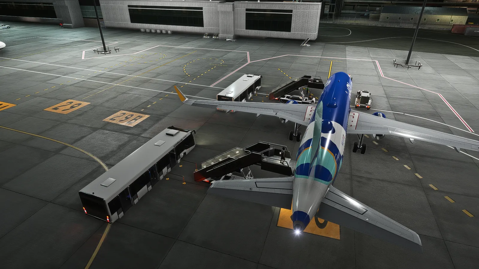 Night view from above of an airliner at a remote stand with stairs at both doors and two apron buses.